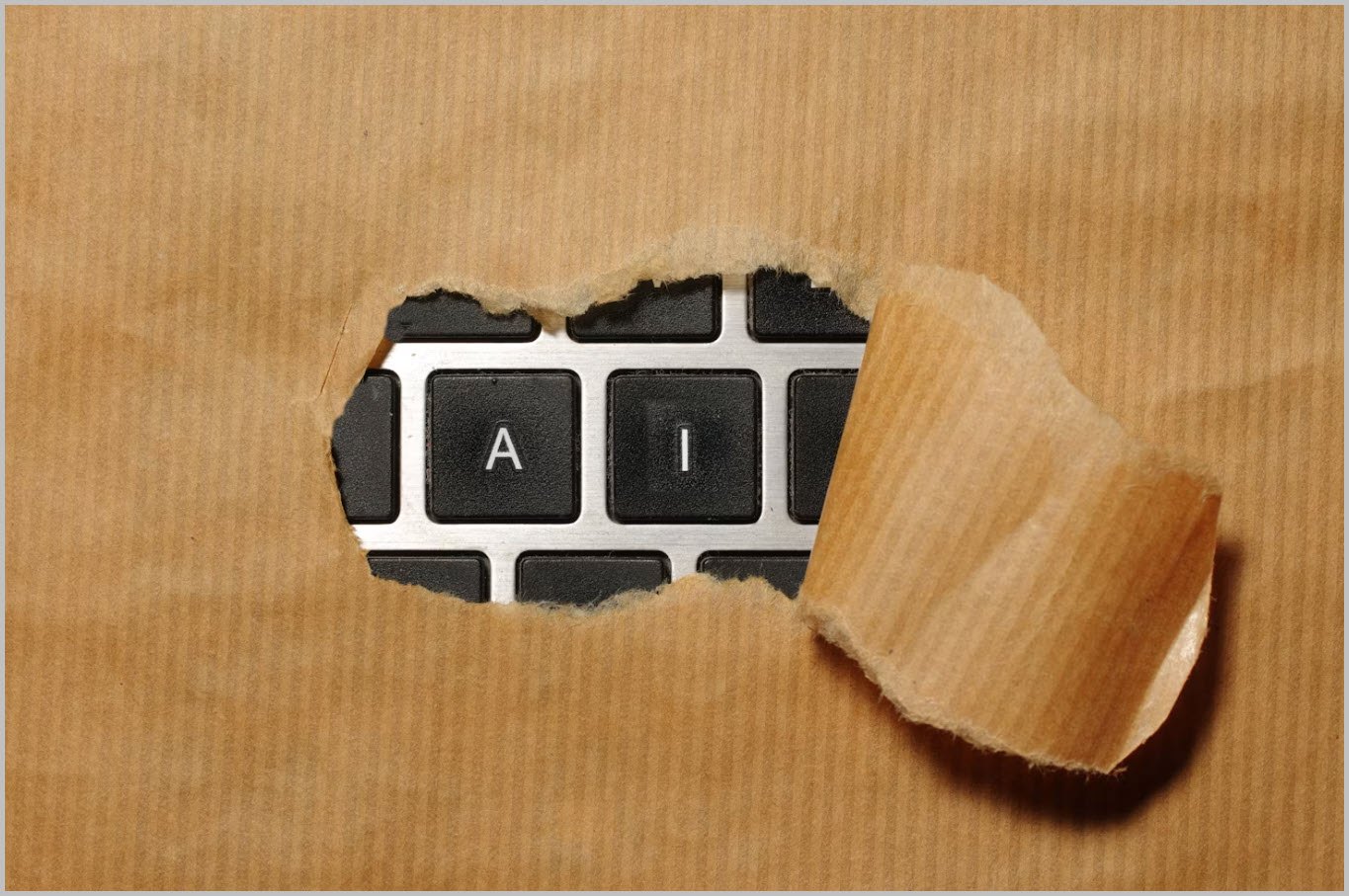 A keyboard with AI keys revealed behind torn paper